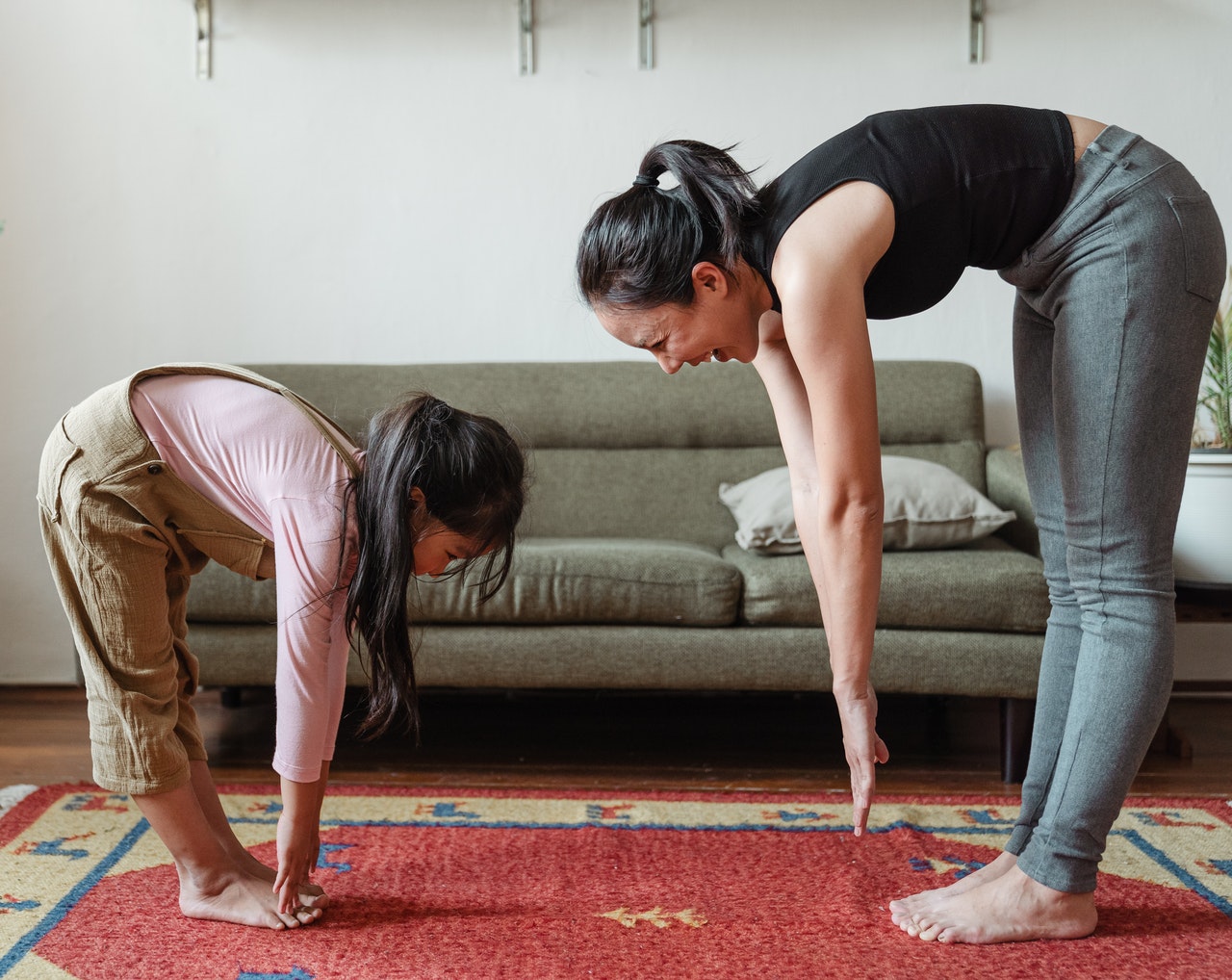 woman doing yoga at home with daughter