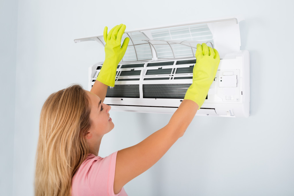 woman fixing an air-conditioning unit