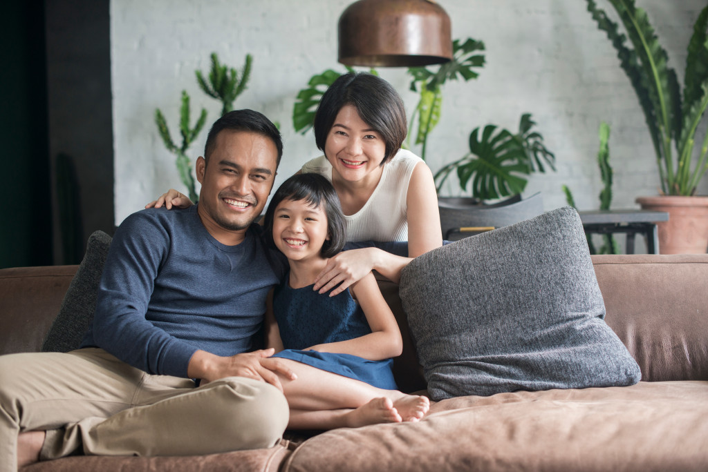 asian family having a pictorial in their brown couch in the living room