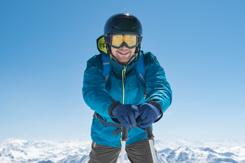 man wearing blue hiking gear climbing a snowy mountain