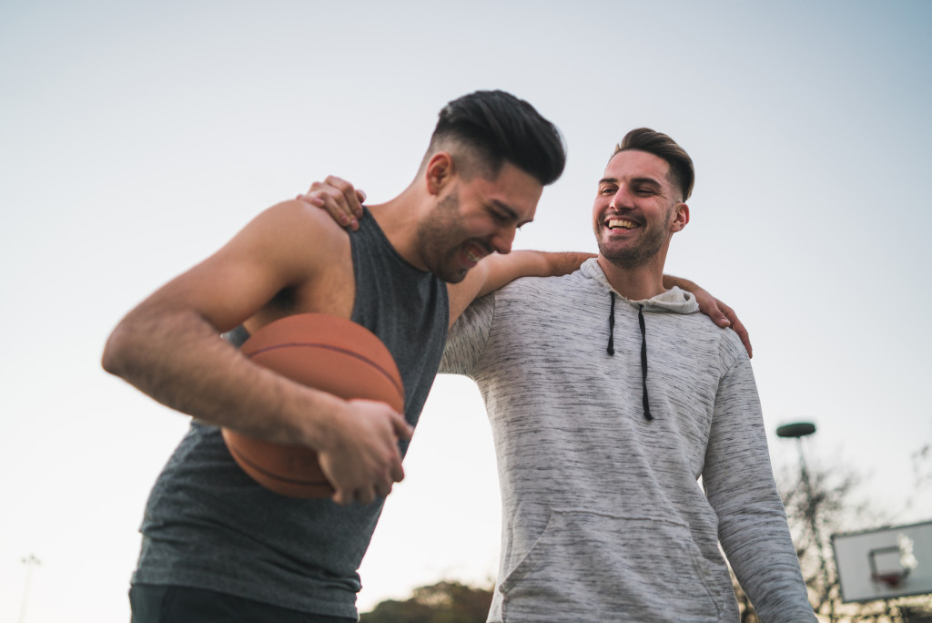 Two mean smiling after playing basketball