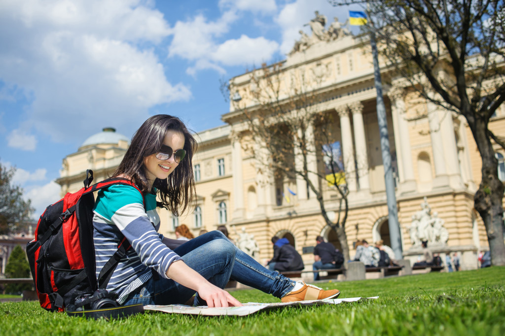 student sitting on university's landscape