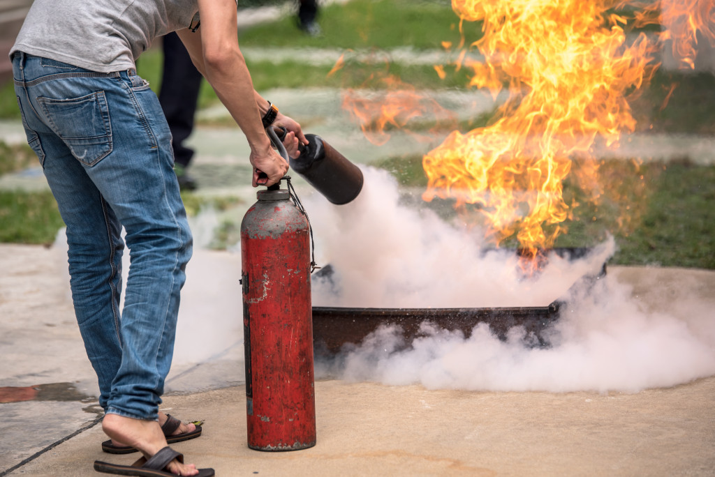 A man using a fire extinguisher to kill a fire