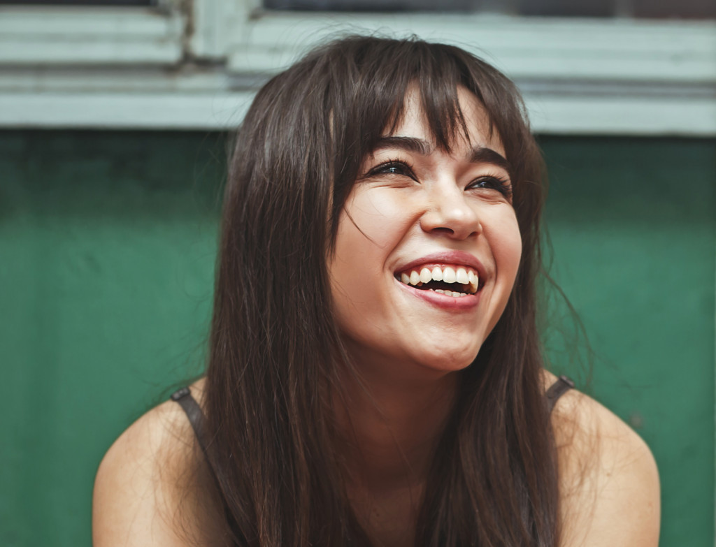 A woman smiling with a green background