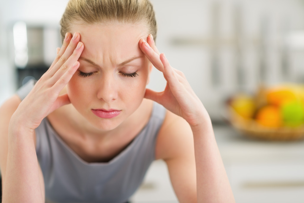 stressed woman at home with her hands on her forehead