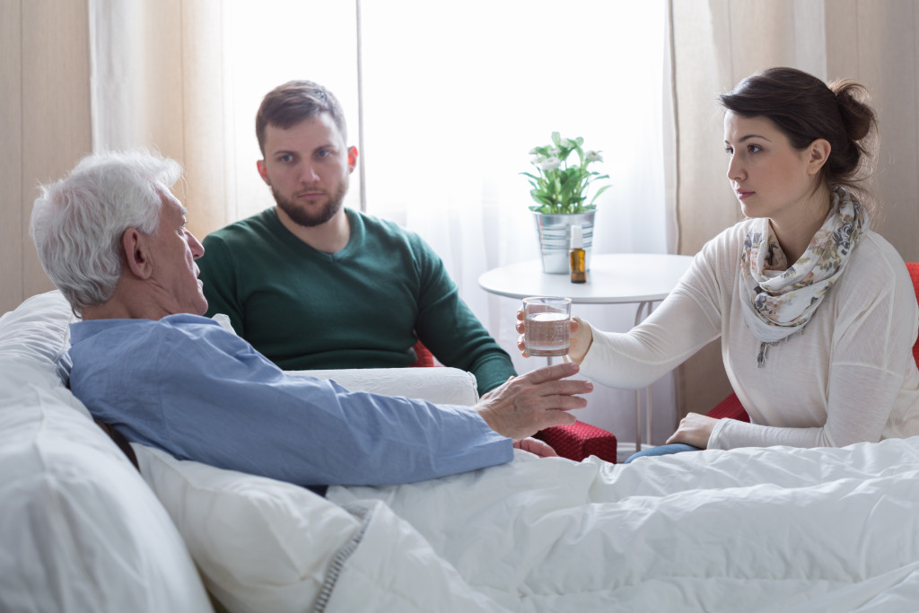 children caring for terminally ill dad in hospital bed