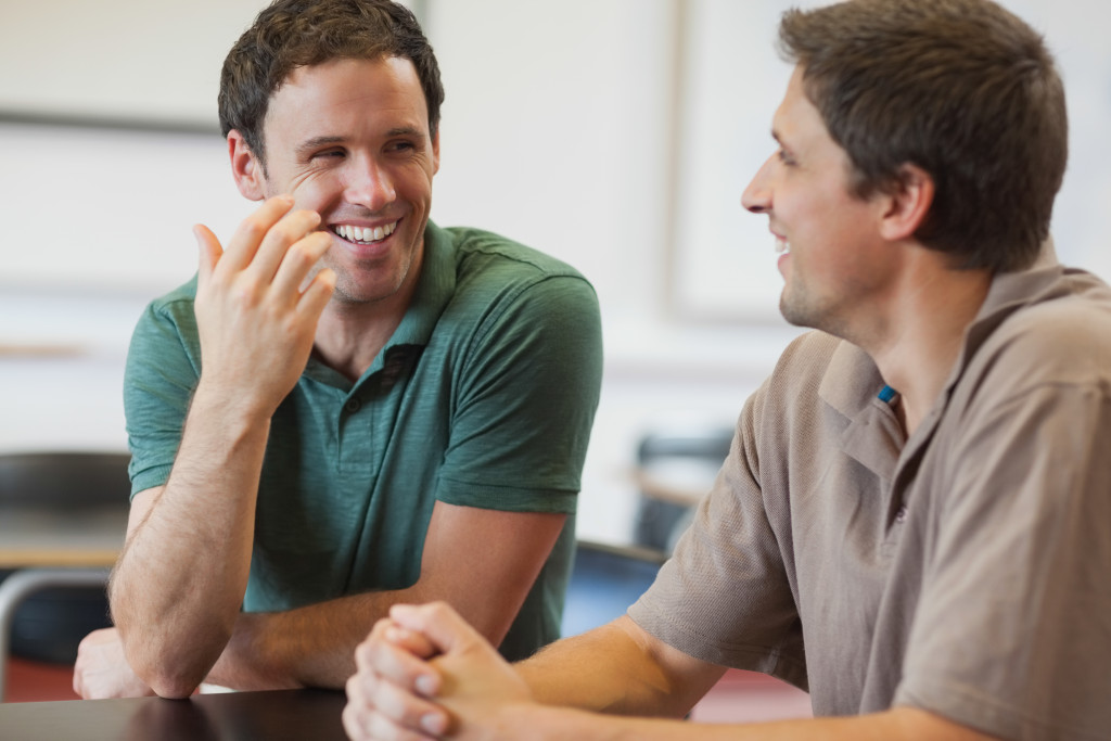 Two male friends having a light, happy conversation