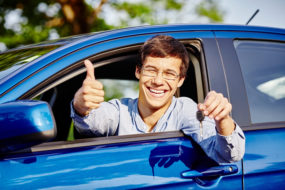 man giving a thumbs up while inside his car