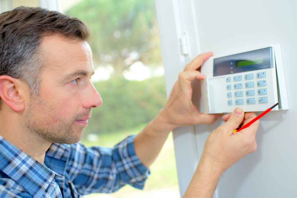 male electrician insalling a security system at home