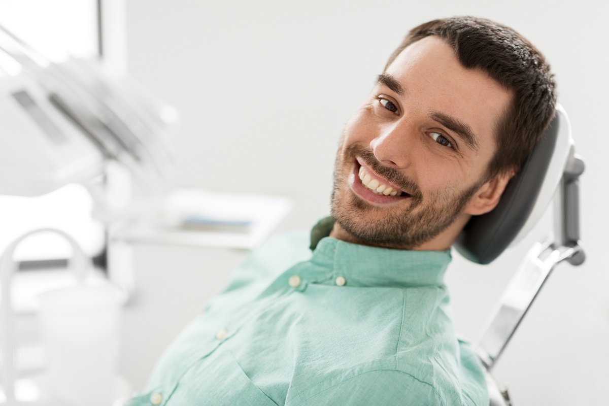 man sitting on a dental chair smiling