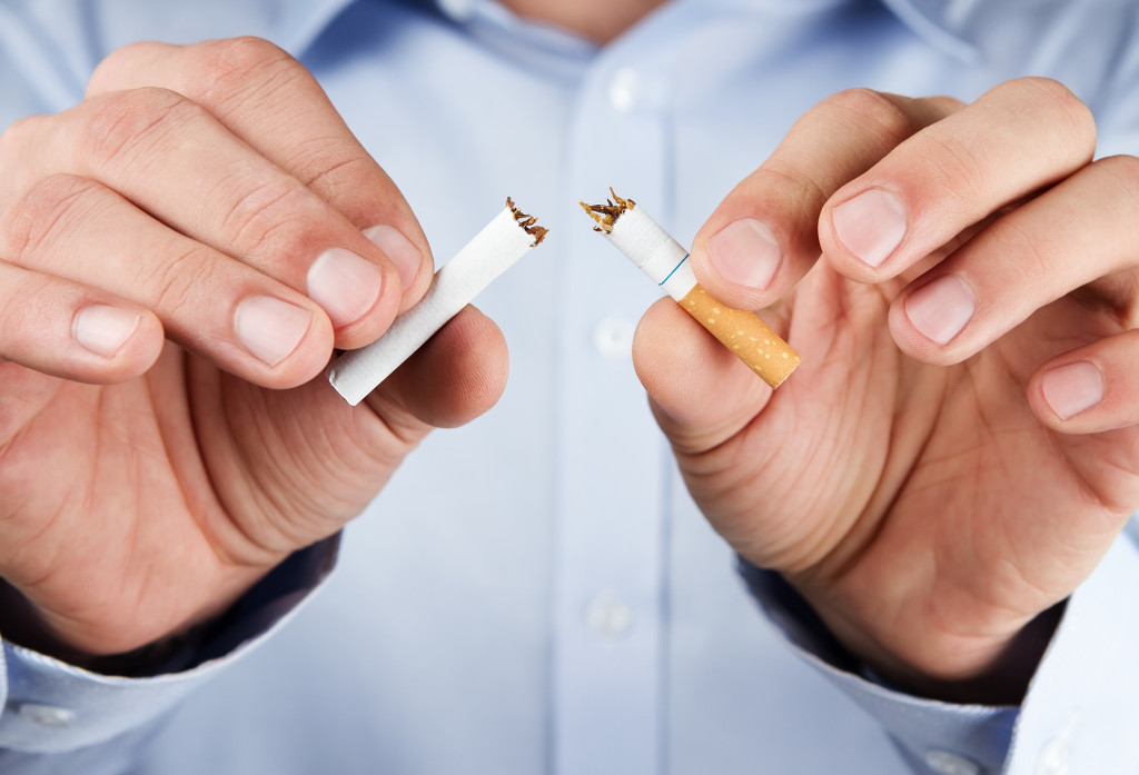 A person breaking a cigarette in half