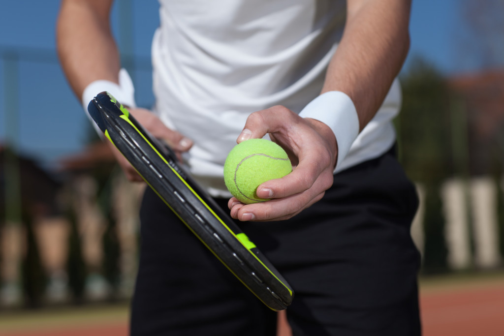 tennis player holding a racquet and ball